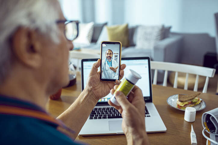 Digital health and social care plan: Close up of a senior man consulting with a doctor on his phone

