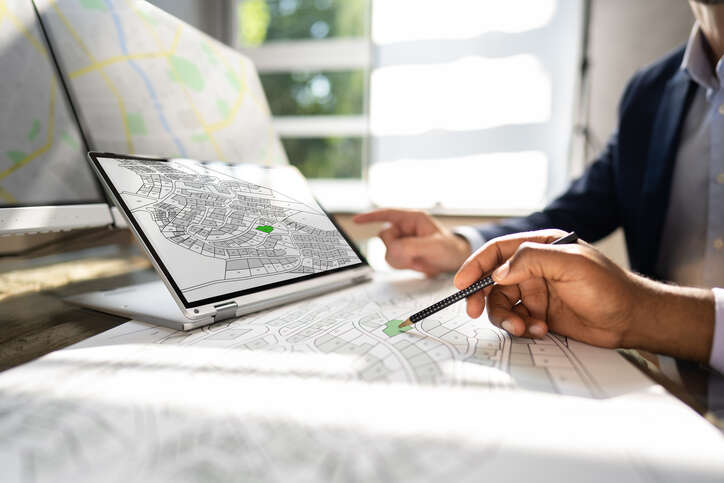 Digital transformation HM Land Registry. Cadastre Map And City Building Survey On Laptop. 
