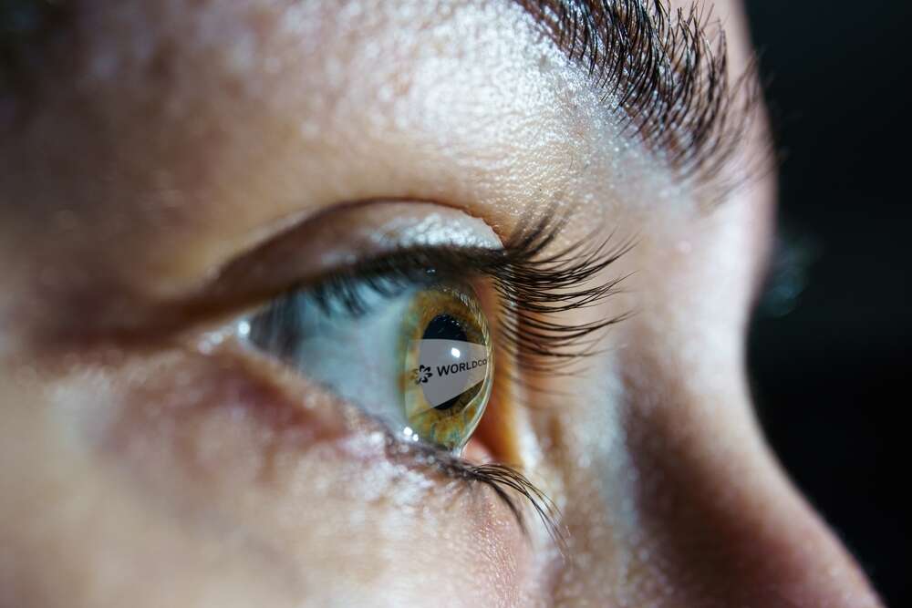 The logo of the company Worldcoin reflected in an individual's eye. 