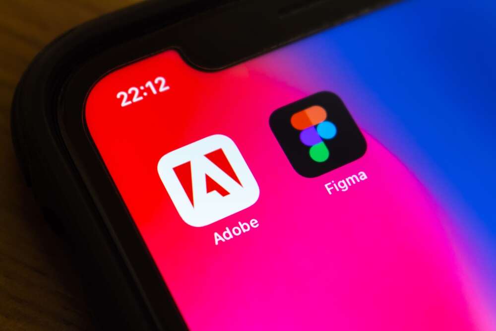 The icons of Adobe and Figma on a mobile phone.