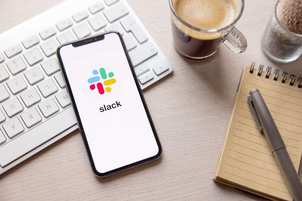 A photo of a mobile phone showing the Slack logo on its screen, used to illustrate a story about the rollout of new Slack AI features.