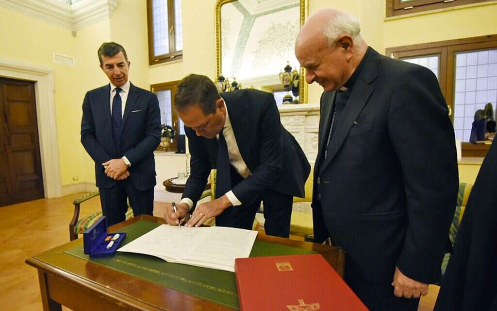 A photo of a Cisco executive signing the Rome Pact in the presence of Archbishop Vincenzo Paglia, used to illustrate a new story about the company's signing the Rome Call AI pact.