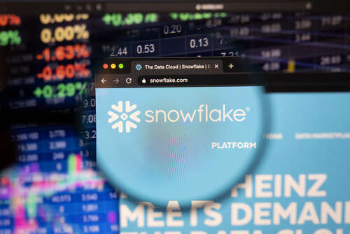 A photo of the Snowflake logo in a magnifying glass, used to illustrate a story about the release of its new LLM Arctic.